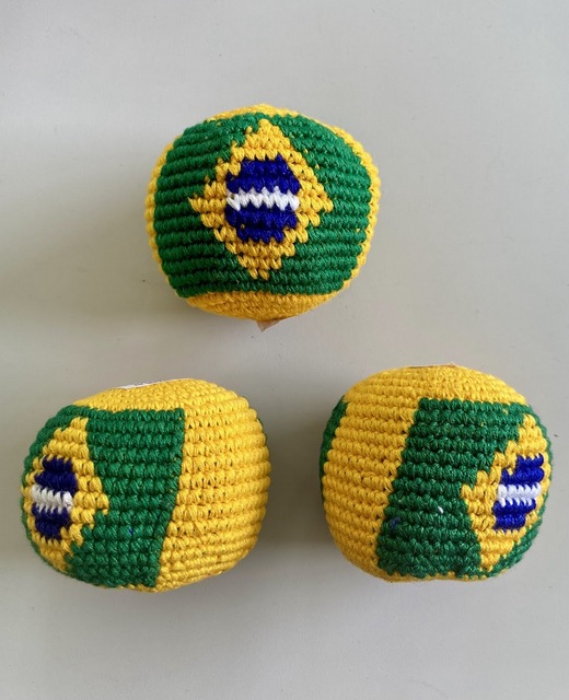 Hand-crocheted cotton footbag displaying the green yellow and blue Brazilian Flag theme design.