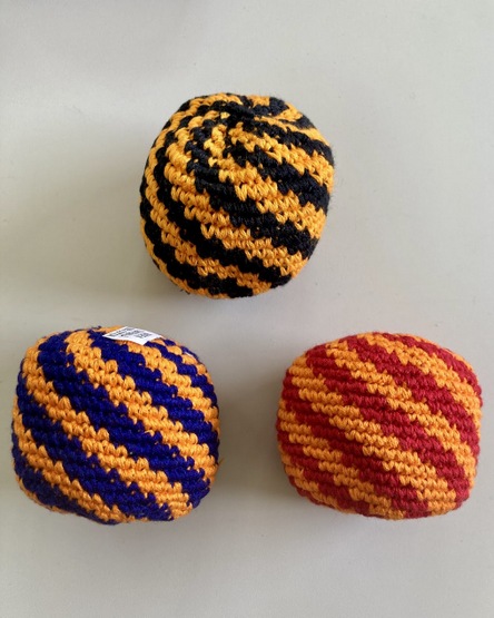 Artisan hand-crocheted cotton footbag woven with a colorful thin spiral pattern design.